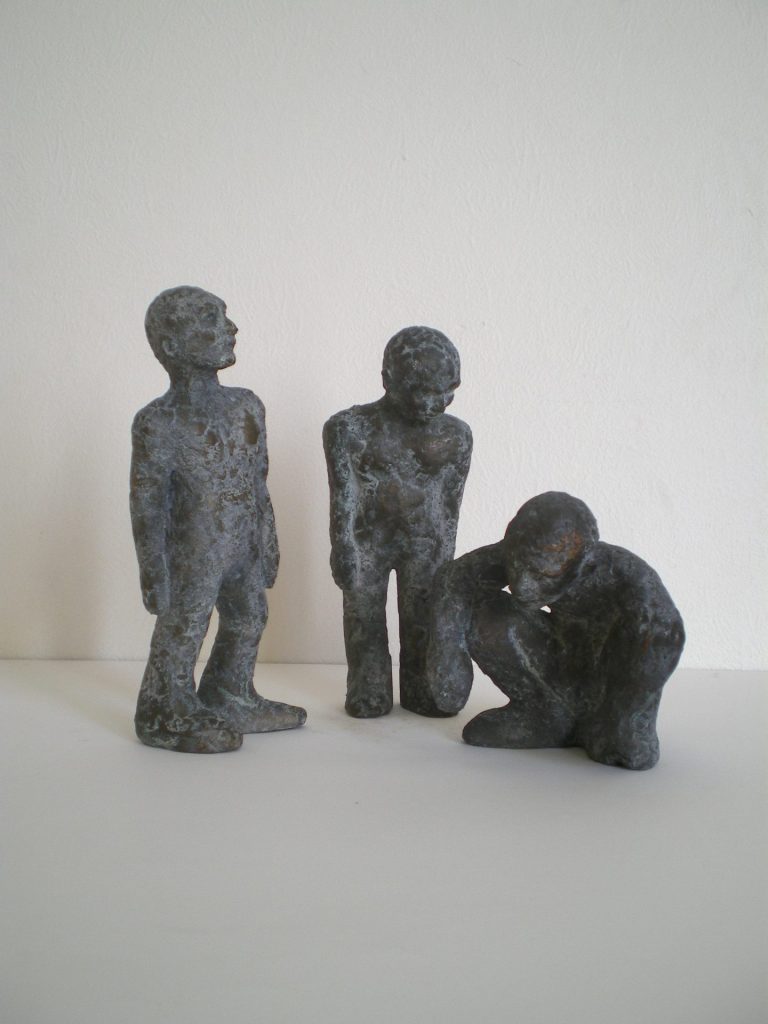 Gruppe von drei Männlichen Skulpturen aus  Bronze, zwei davon stehen, einer hockt