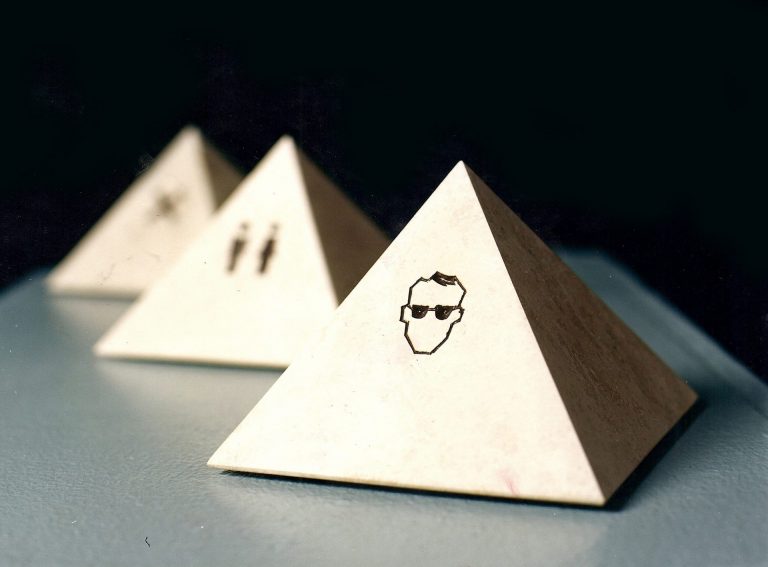 Gruppe von drei Pyramiden aus geschliffenem  Jura-Kalkstein, die vorderste hat ein  Piktogramm eingraviert, daß zum Tragen einer  Schutzbrille auffordert