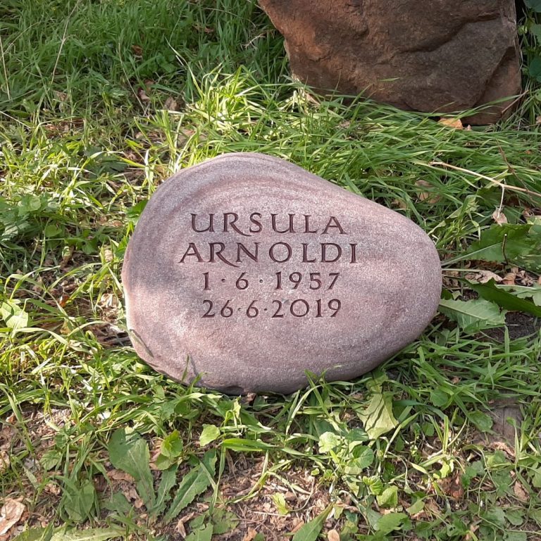 Rötlicher Sandstein-Findling für ein Baumgrab mit tief  eingenuteter, braun getönter Kapitalis-Quadrata