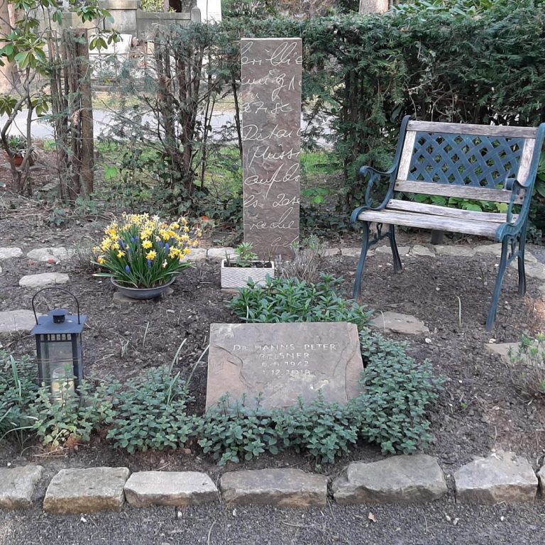 Rechteckige Grabstele aus Ruhrsandstein mit natürlich gebrochener Vorderfläche und in den Stein gehauenem, vergrößertem Ausschnitt einer Handschrift des verstorbenen