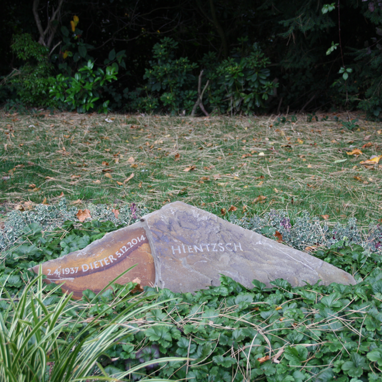 Grabstein-Liegekissen aus Ruhrsandstein-Felsen in dreieckiger Form mit unterschiedlich gefärbten Schichten