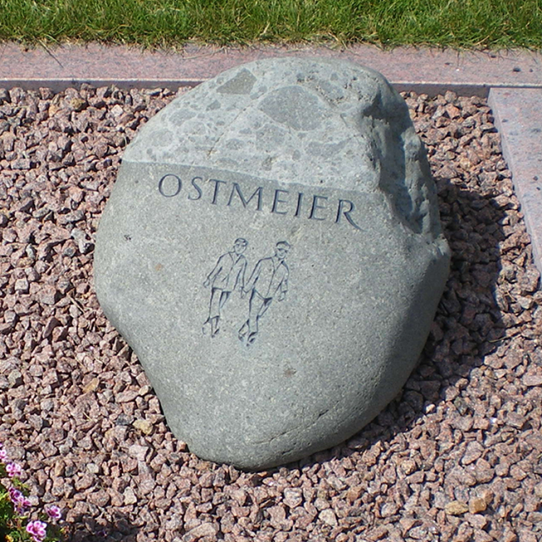 Grüner Grabstein-Findling mit Brekzien-Einschlüssen für ein  Doppelgrab, mit eingehauener, getönter Schrift und dem Motiv  eines Paares beim Spaziergang