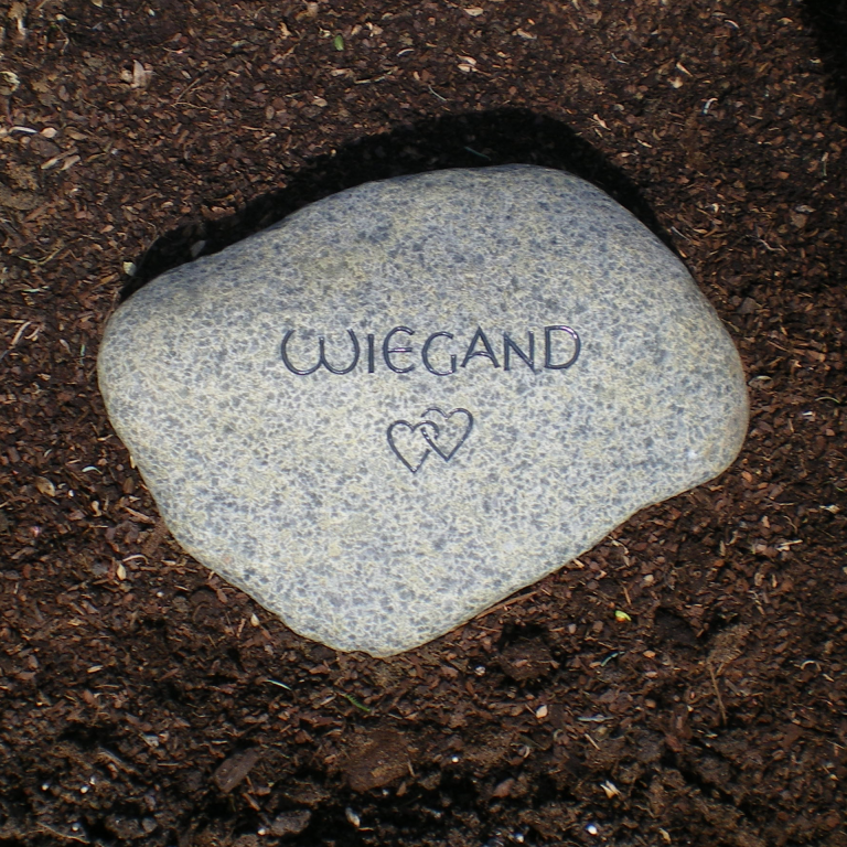 Schlichter, grünlich gepunkteter Findling-Grabstein für ein  Baumgrab, mit Zwei-Herzen-Ornament