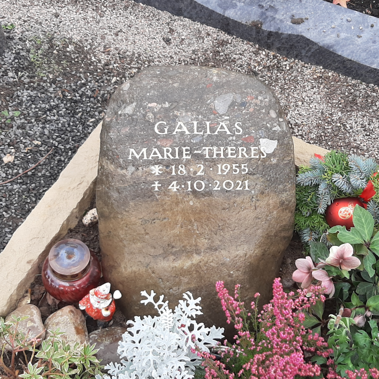 Urnengrab mit Bräunlichem Grabstein-Findling aus einer Brekzie,  mit eingehauener Schrift und einer Einfassung aus Baumberger  Sandstein