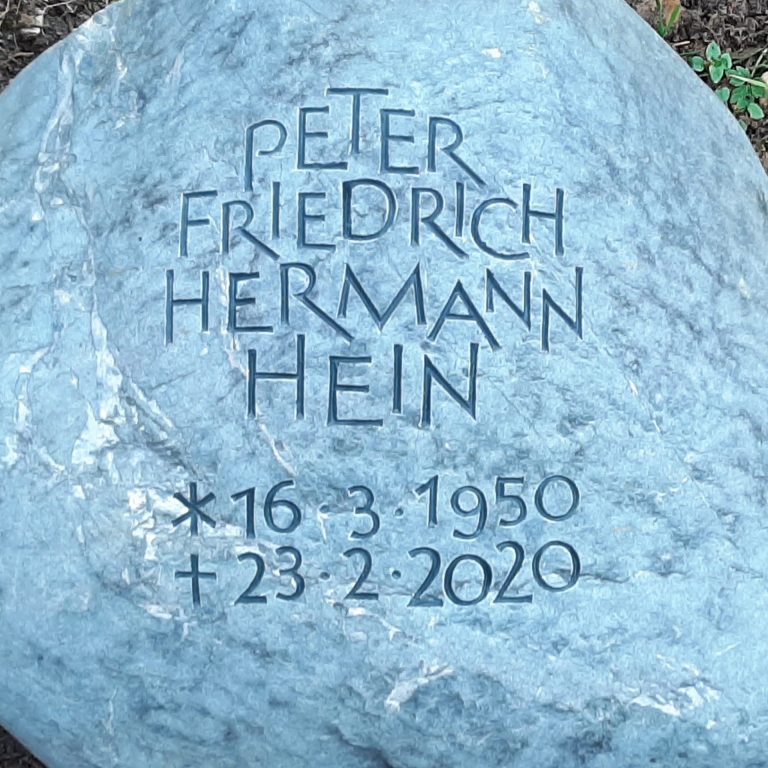 Ornamental angeordnete Beschriftung, tief eingenutet in einen  Findling