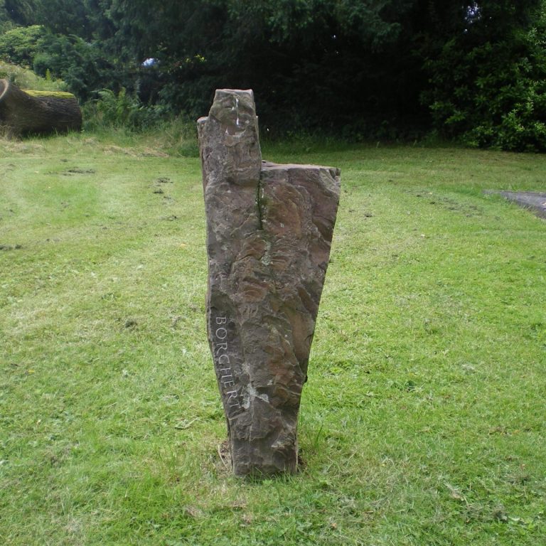 Felsen-Grabstein für ein Einzelgrab in Form einer Kirche mit senkrecht verlaufender, handwerklich eingemeißelter Schrift