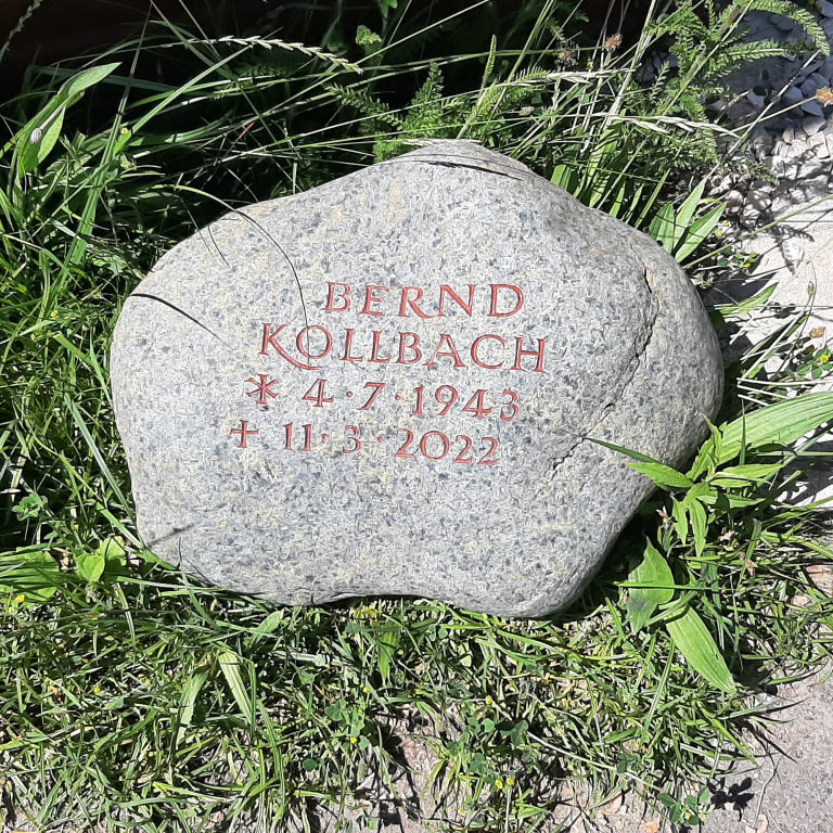 Grünlich gepunkteter Grabstein-Findling für ein Baumwahlgrab  mit tief eingravierter, rötlich getönter Inschrift