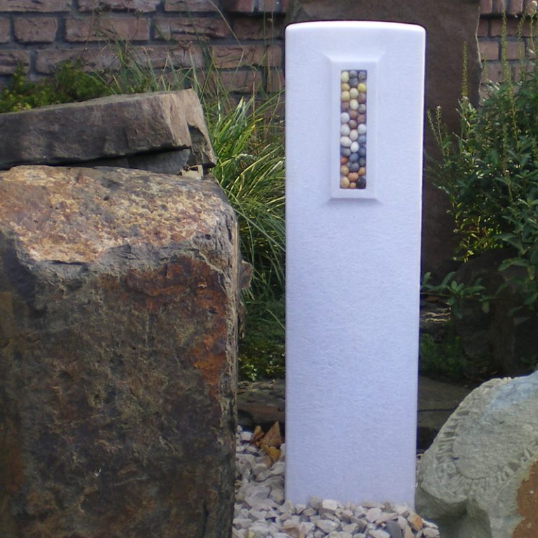 Kleine Urnengrab-Stele aus weißem, Steinmetz-mäßig bearbeitetem Marmor mit eingelassenen, farbigen Muscheln