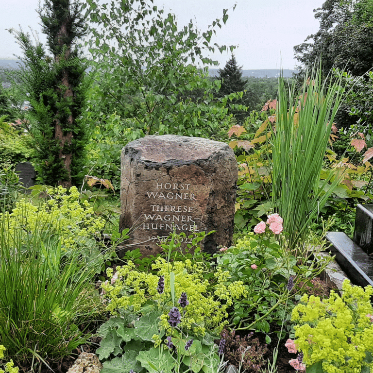 Kleine Basaltsäule mit handwerklich eingearbeiteter Schrift und Grabumrandung aus Grauwacke-Mauersteinen