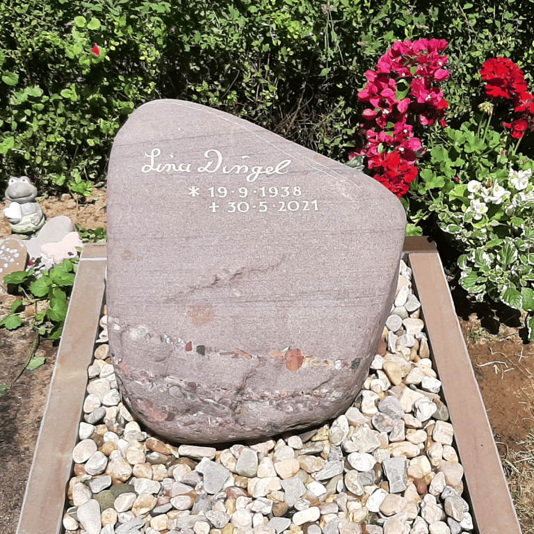 Roter Sandstein-Brekzien-Findling aus Frankreich mit Einfassung aus Bergischer Grauwacke, Einzelgrab aufgefüllt mit Rheinkies