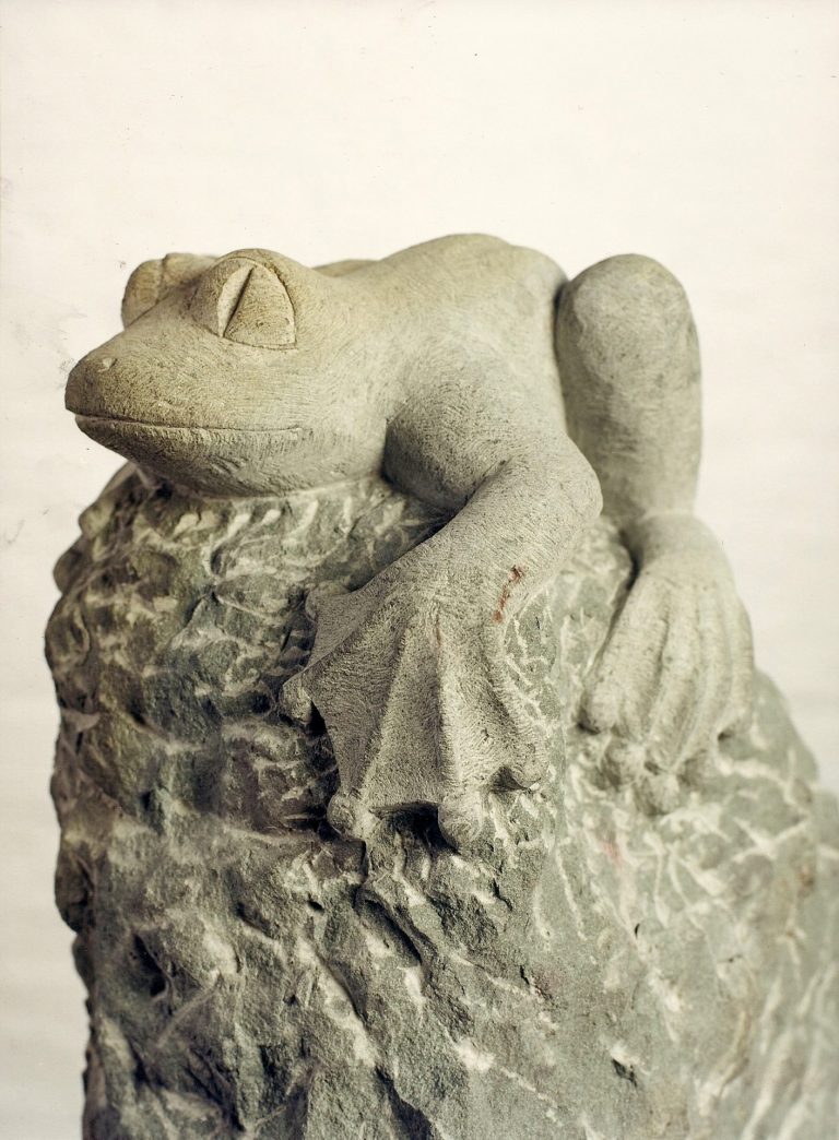 Vorderansicht einer Skulptur eines kletternden  Frosches aus Anröchter Grünsandstein
