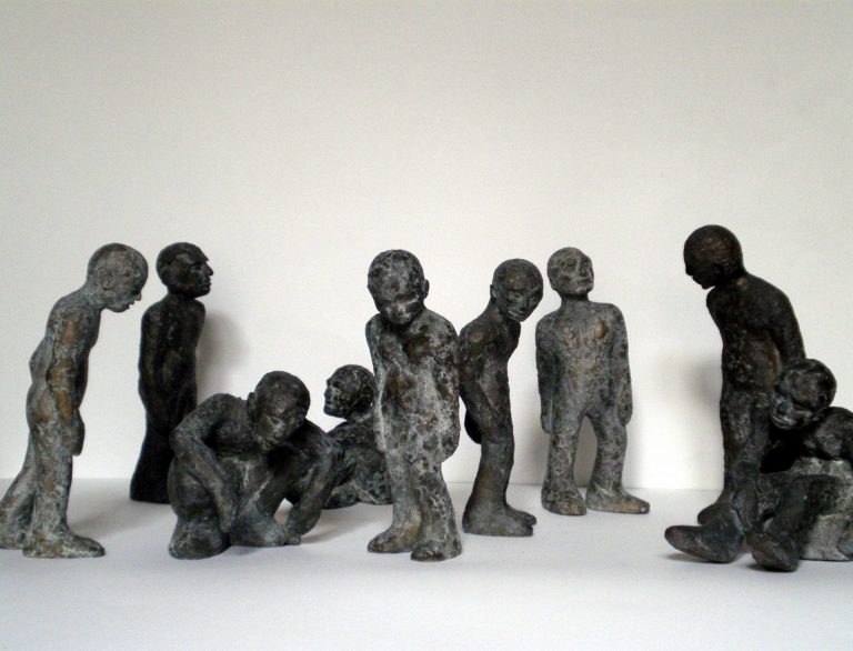 Gruppe von anthropomorphen Skulpturen aus  Bronze und Wachs, die durch ihre Haltung und  Mimik miteinander kommunizieren