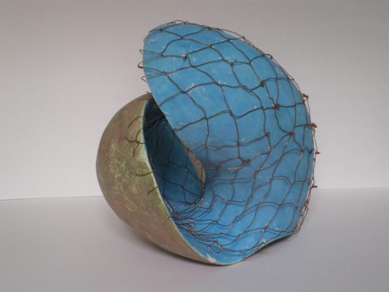 Rundliche, amorphe Plastik, deren mit  Kupferdraht bespannte Innenfläche sich nach  außen, und deren Außenfläche sich nach Innen  wendet