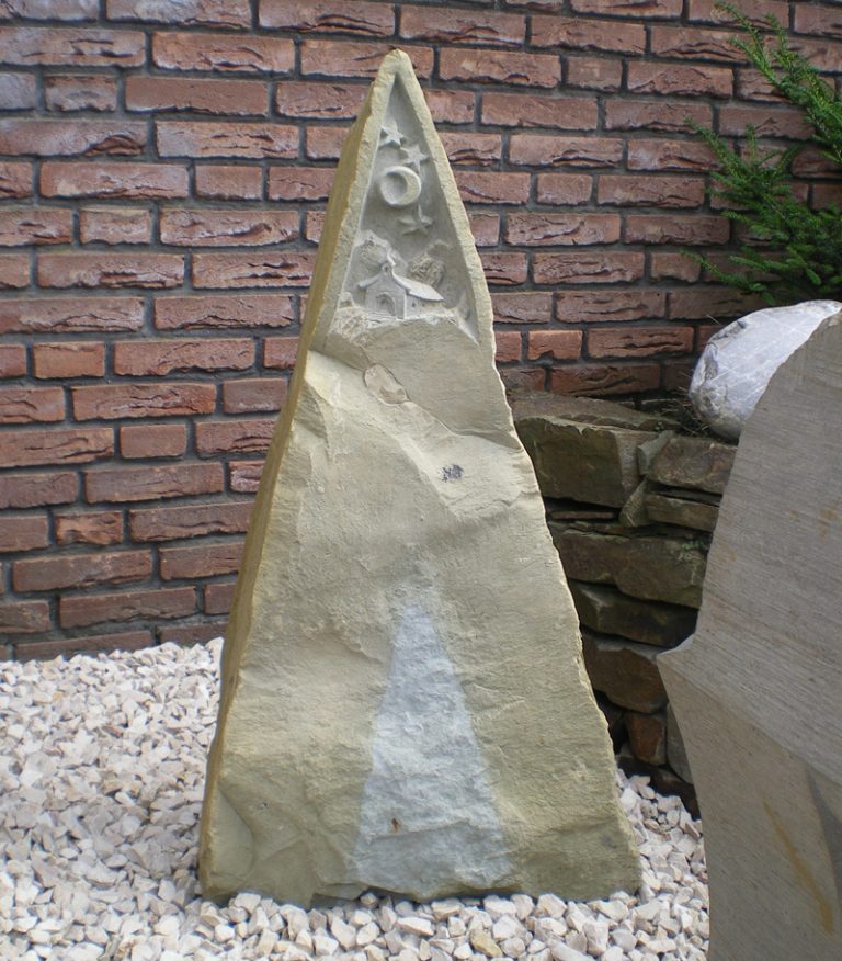 Natürlich gebrochener Grabstein in spitzer Dreiecks-Form aus Anröchter Grünsandstein mit einem Ornament, daß eine Bergkirche unter Sternenhimmel darstellt