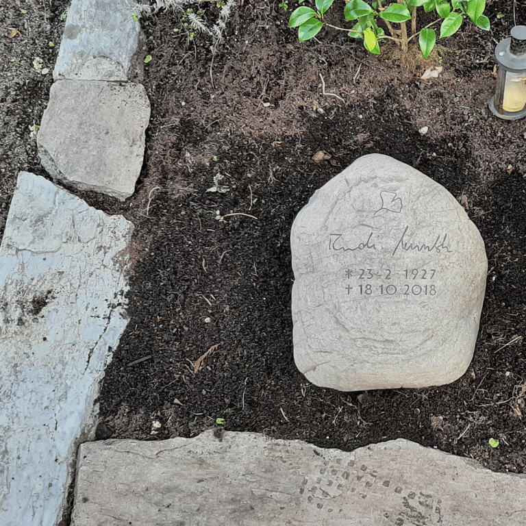 Urnengrab-Findling mit eingravierter Unterschrift des Verstorbenen