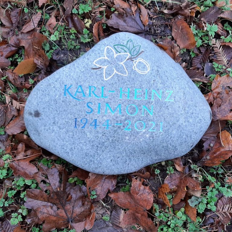 Bläulicher Findling-Grabstein für ein Baumwahlgrab mit  eingraviertem Pflanzenmotiv und getönter, von weiss nach blau  übergehender Schrift